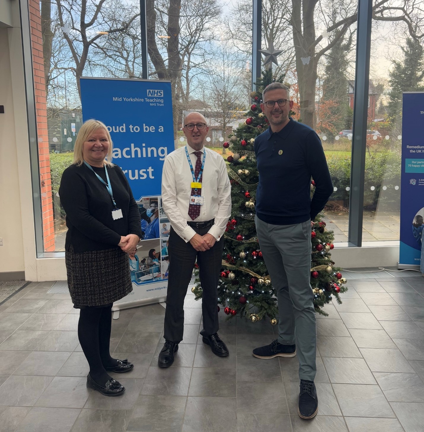 Talib Yaseen with Sovereign health care representatives stood infront of a Christmas tree